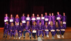 Two rows of students in academic robes pose with their certificates