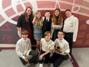 two rows of students pose with musical instruments 