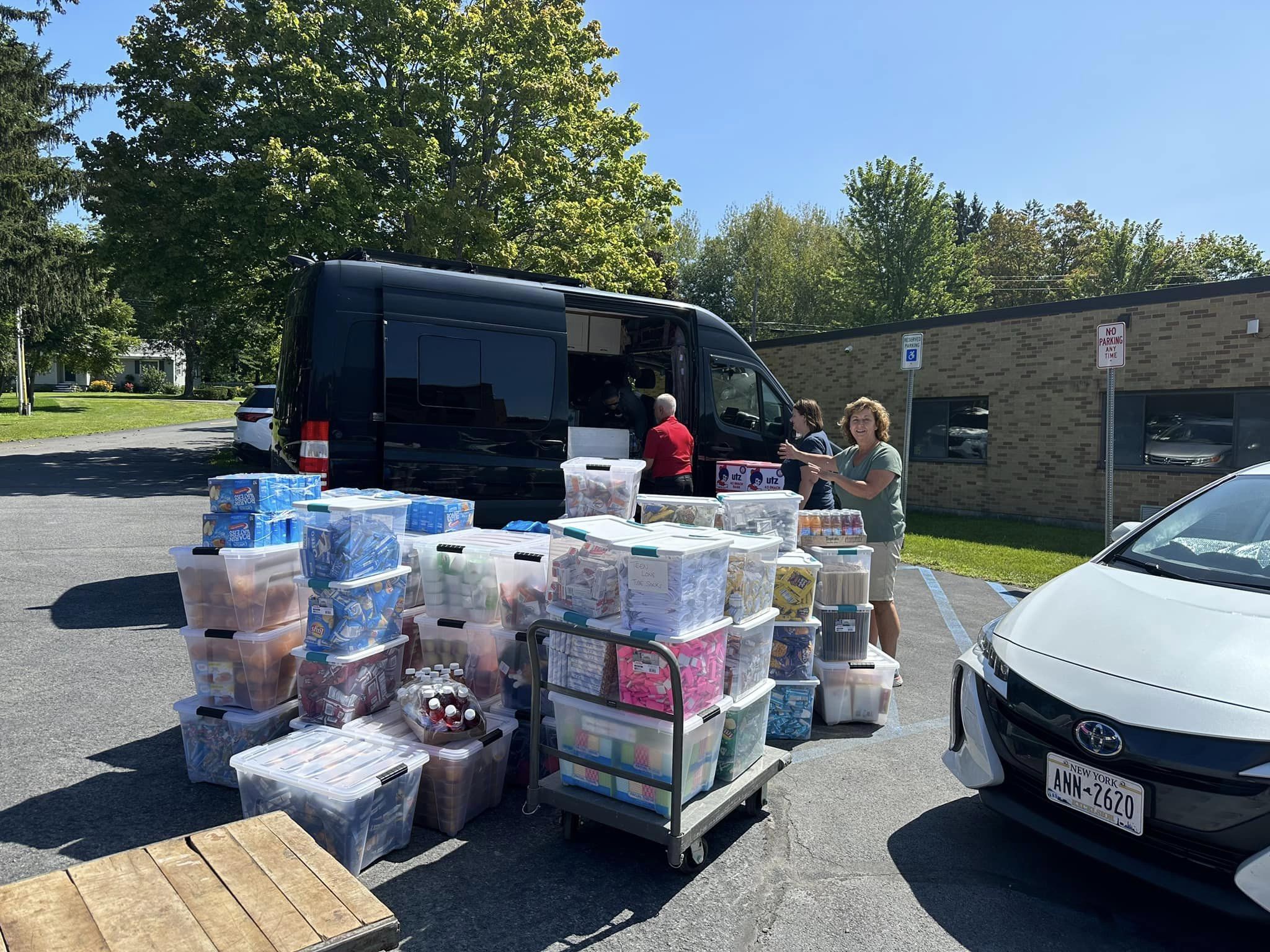 group of people with boxes of school supplies