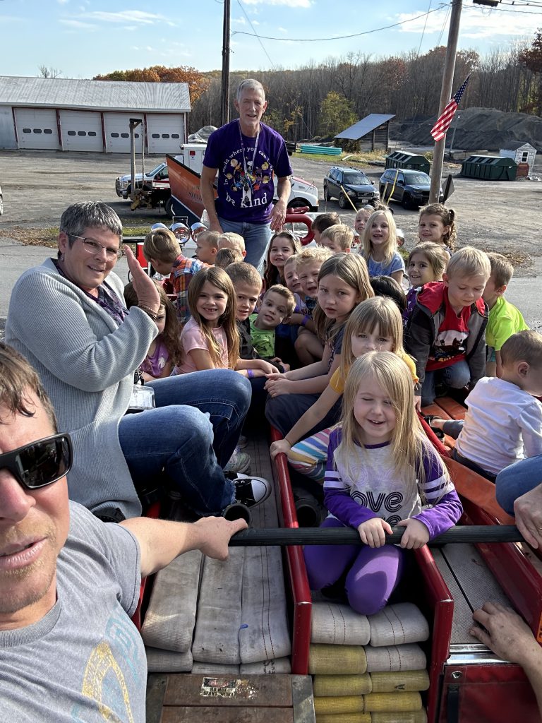 Kindergartners sit atop a firetruck