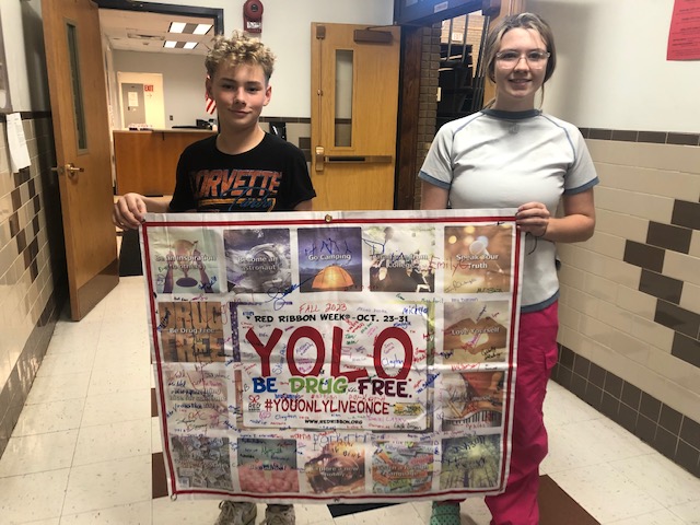 boy and girl hold up a banner