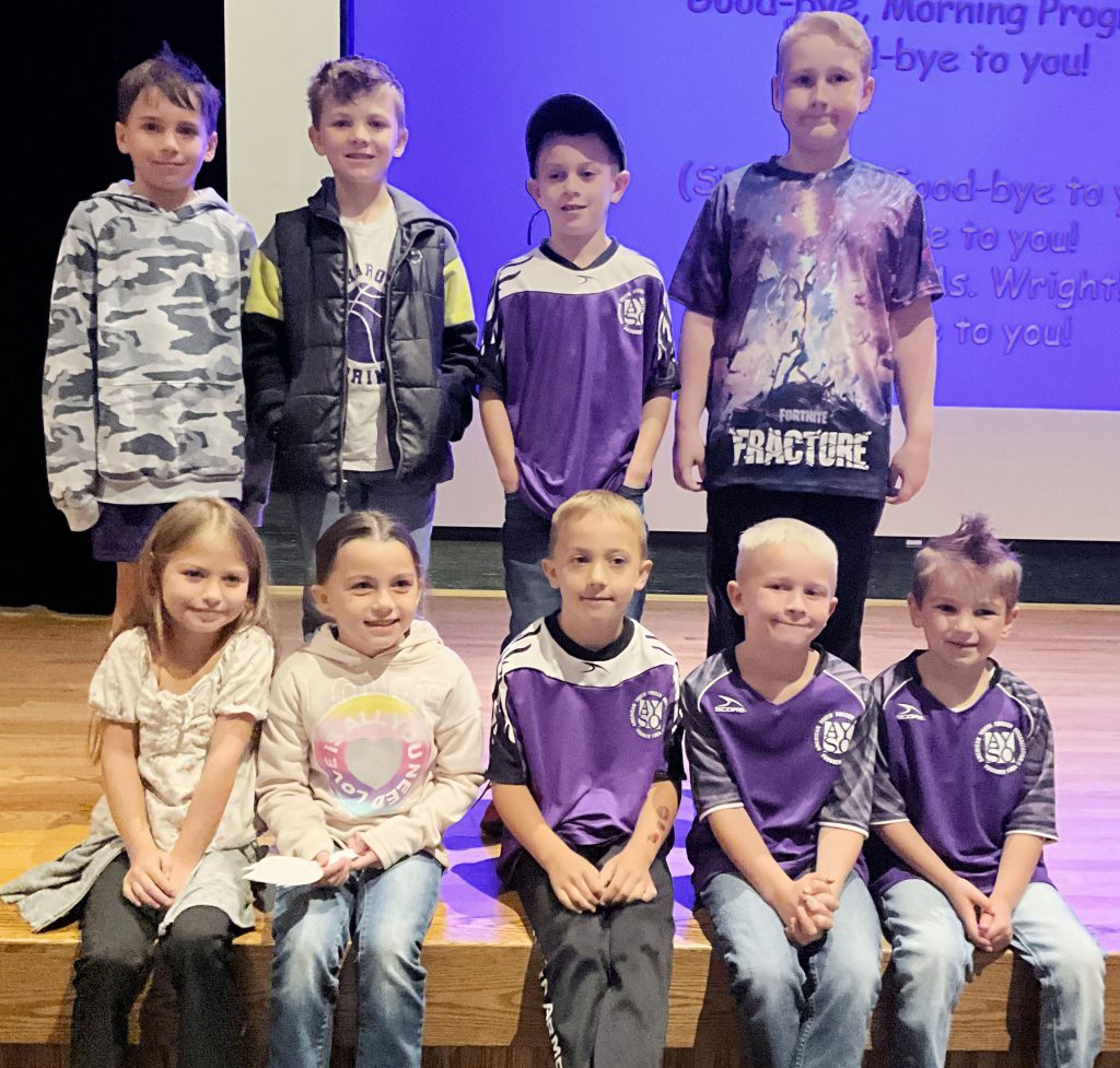 group of young students pose on stage