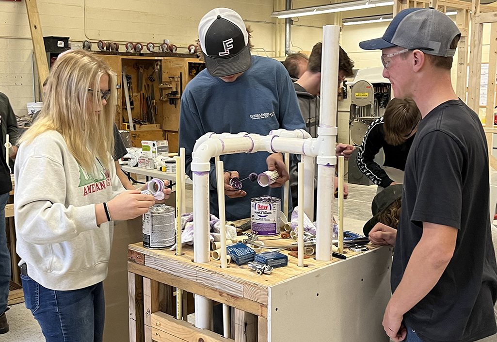 students work on a plumbing project together