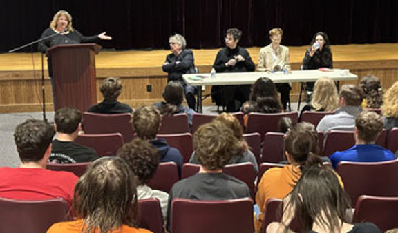 poetry fest visiting authors at a table in the school auditorium