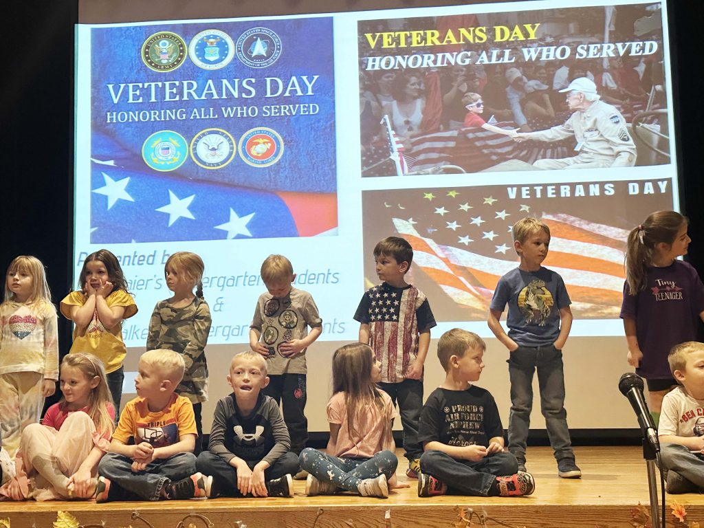 group of youngsters on stage doing a salute to veterans