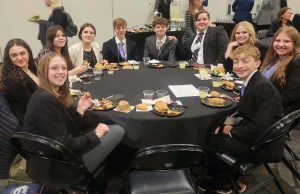 group of students gather at a roundtable