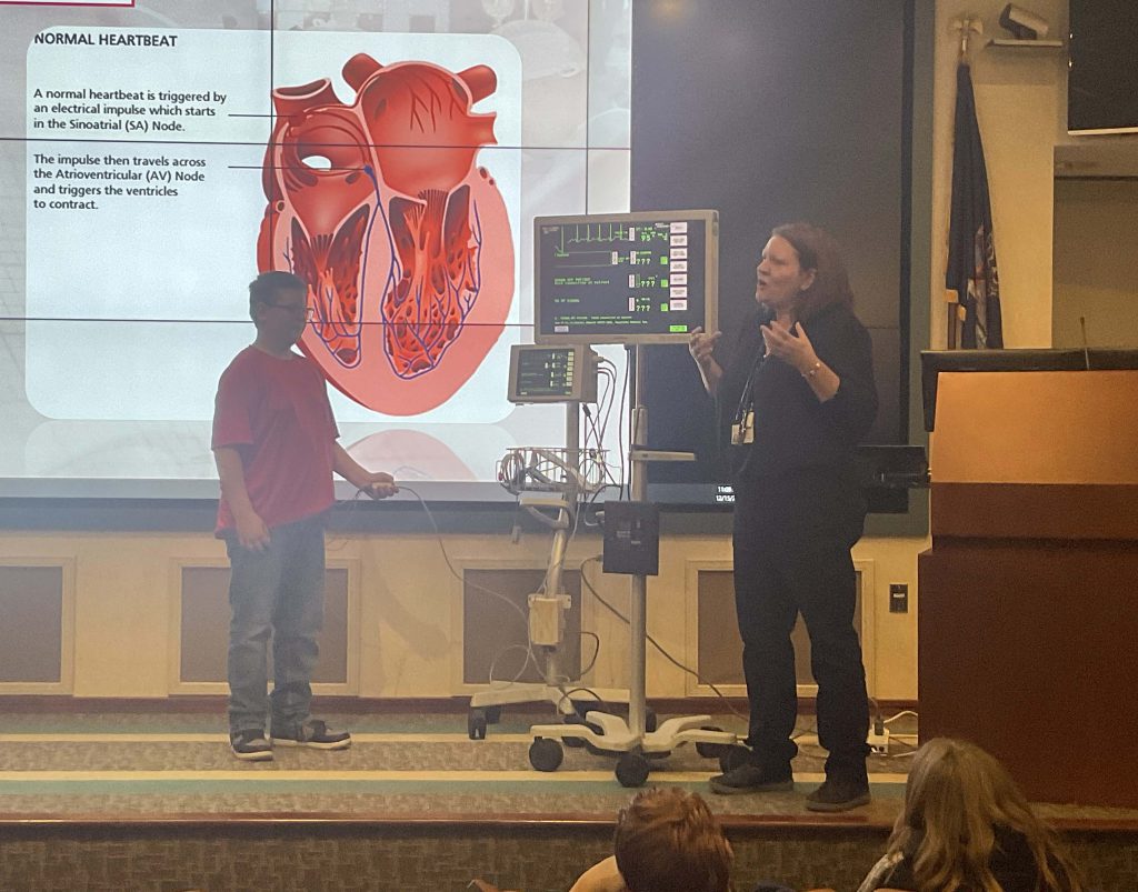 boy on stage learning about heart health from a doctor