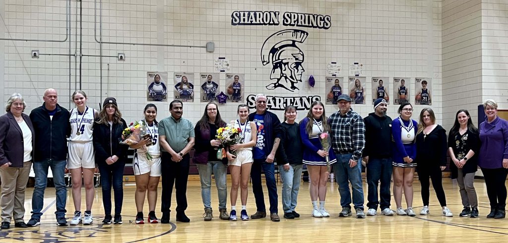 players gather at center court with their coaches and families during senior night ceremony