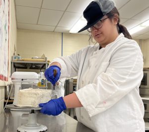 Student chef frosts a cake