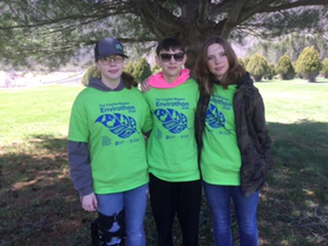 three students in their green shirts