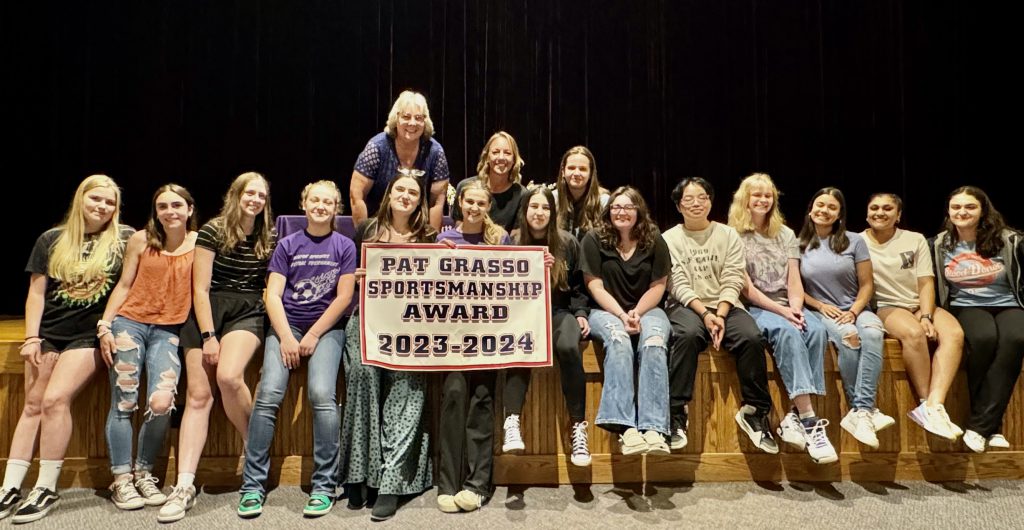 group of girls stand with huge banner
