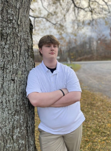 boy standing next to a tree