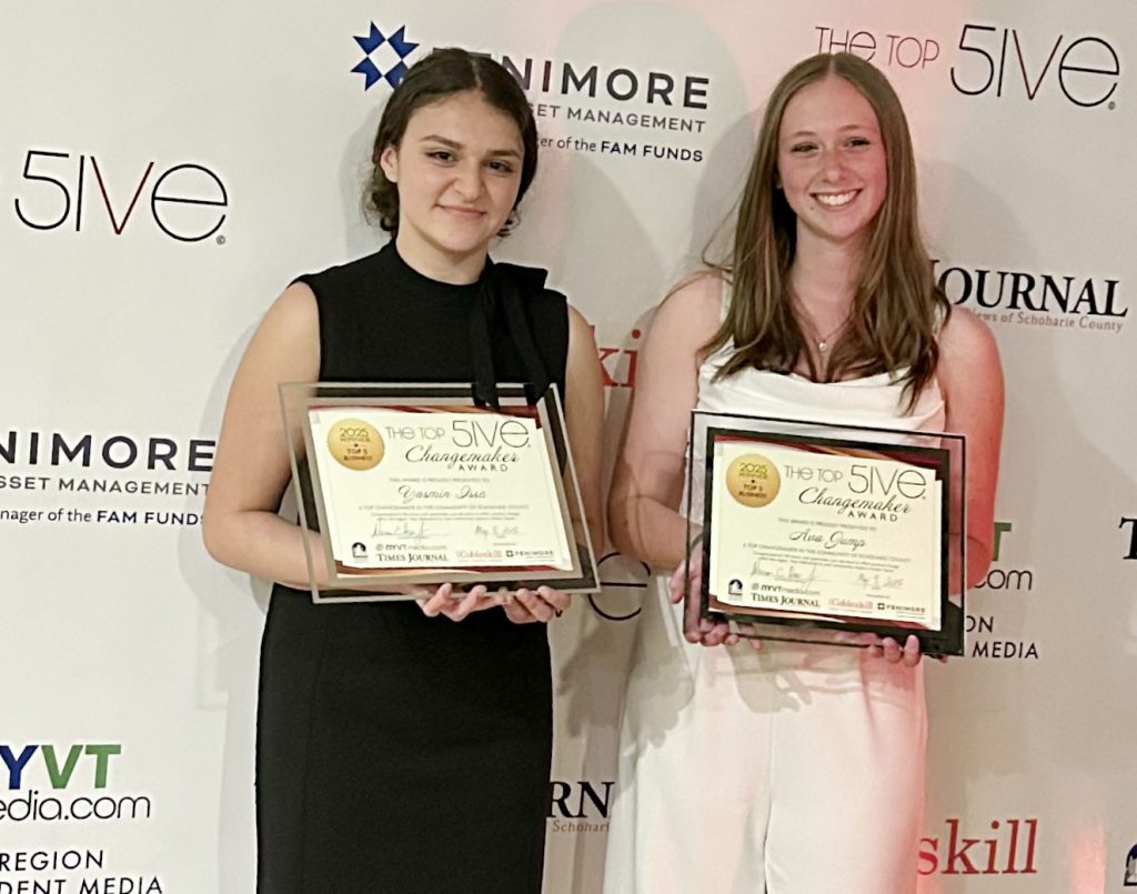 two high school girls holding their award plaques