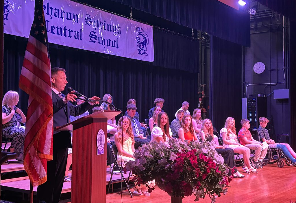 principal addresses group of graduates on stage