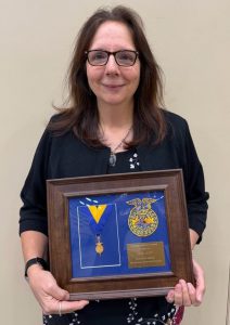 woman awardee holds up plaque