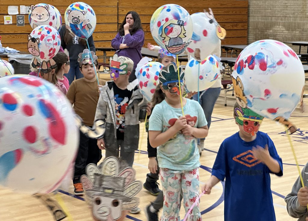 children march around carrying balloons