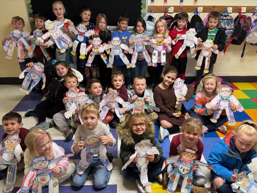 large group of elementary students with their scarecrow projects
