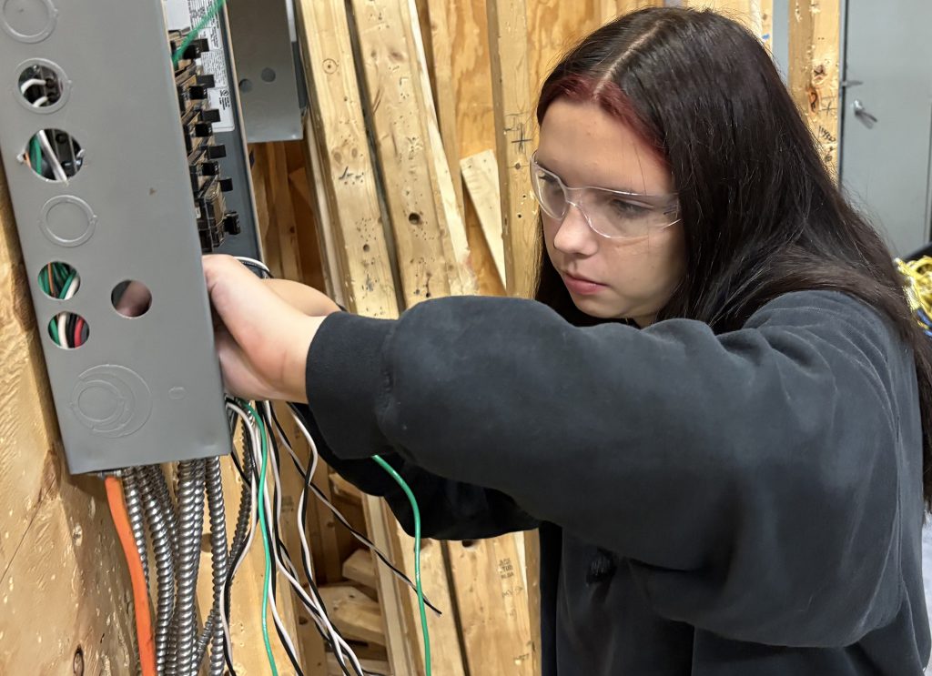 Female electrician works on an electrical box