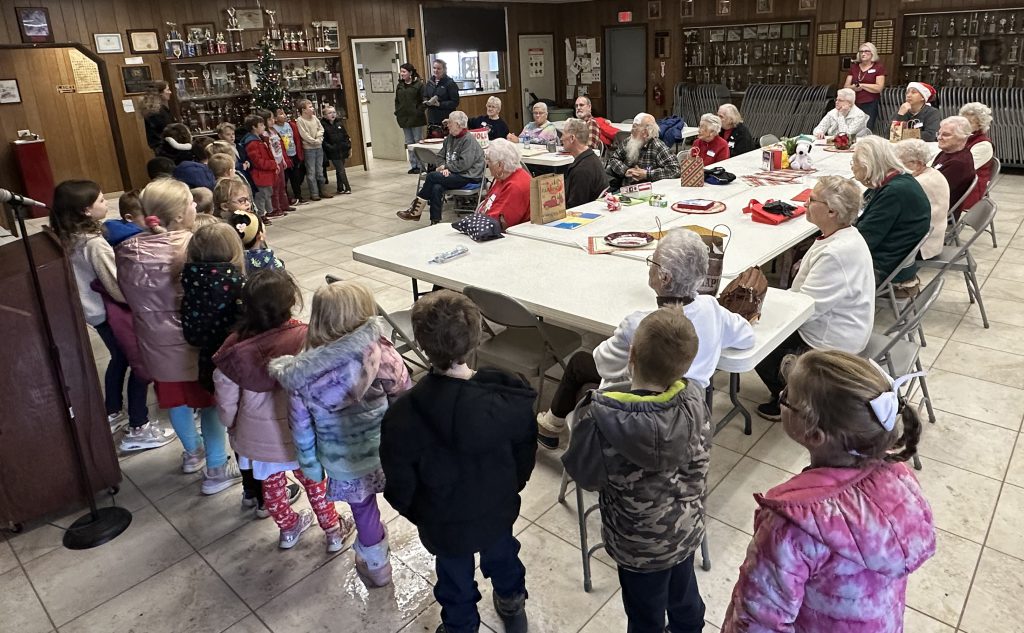 children sing to senior citizens club