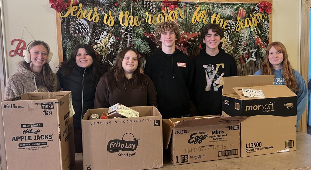 students with the boxes of supplies they collected for food pantry