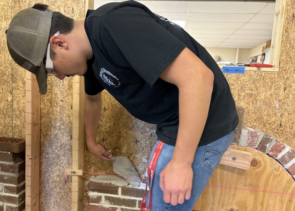 male students tries his hands at bricklaying
