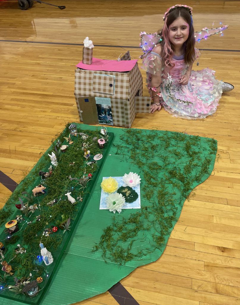 girl in fairry costume show off her cardboard farm