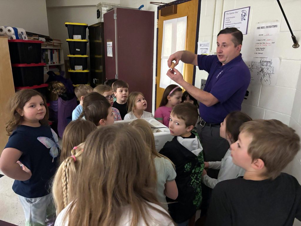teacher speaks to large group of students
