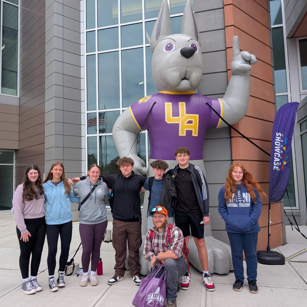 student gather in front of a large inflated great dane dog