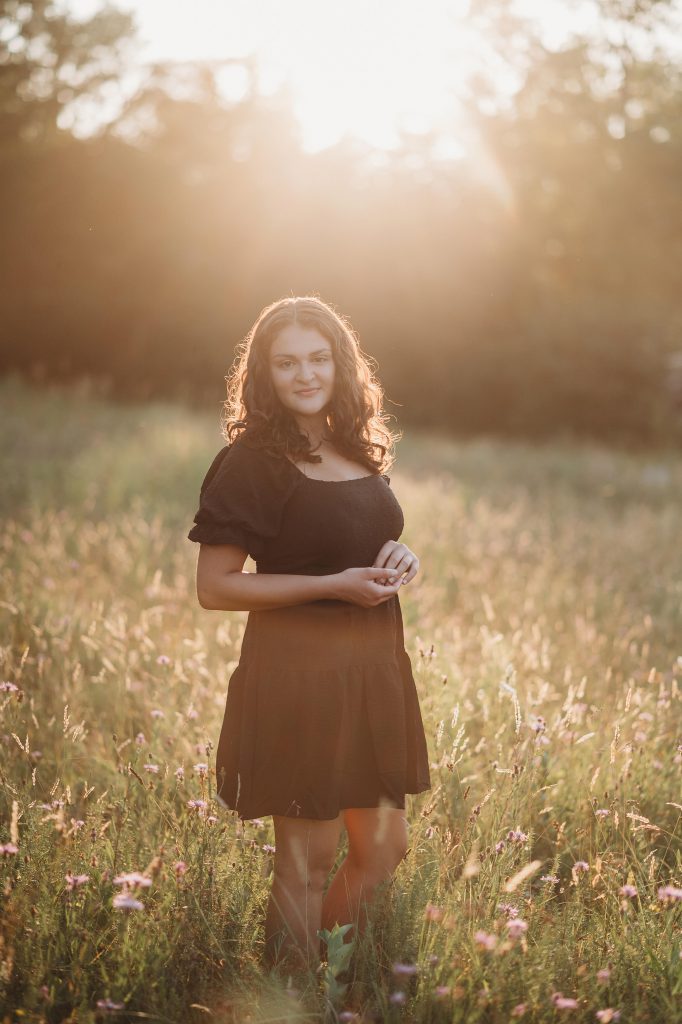 girl poses in a grass field